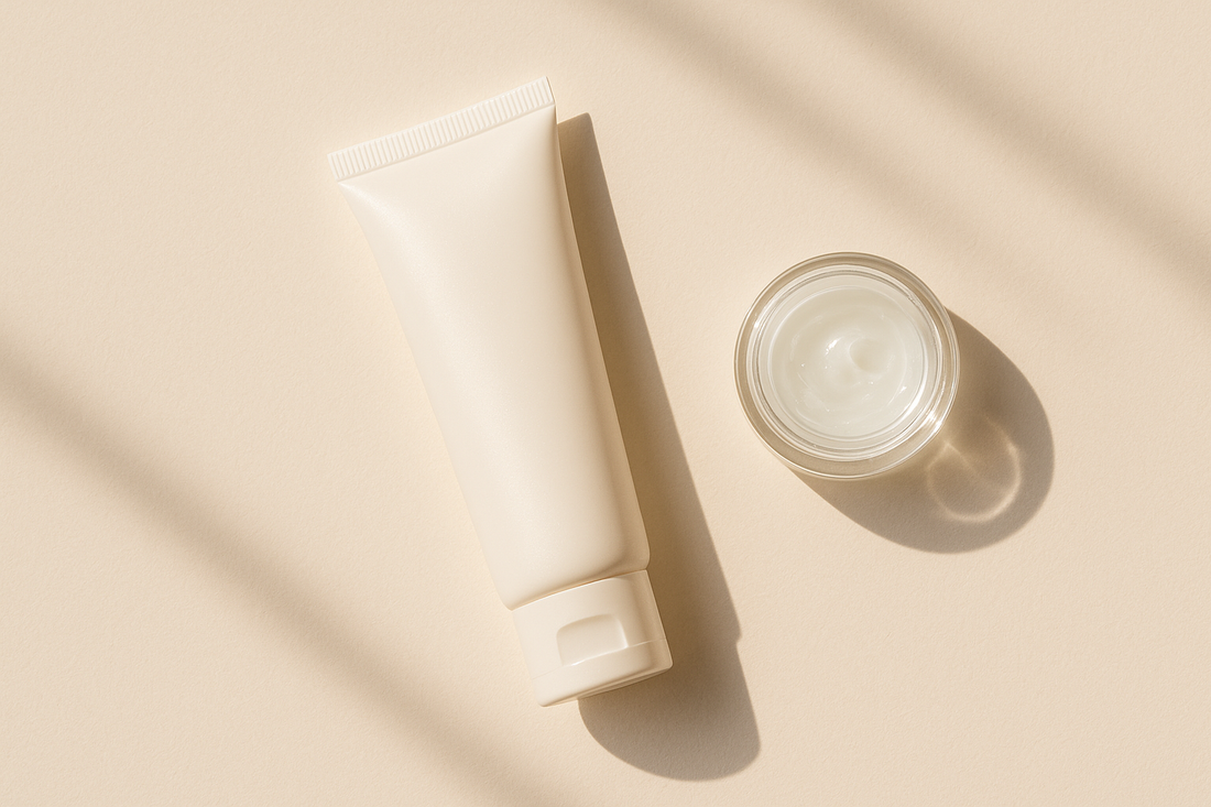 A moisturising sunscreen tube beside an open light gel-cream moisturiser jar on a warm neutral background